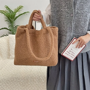 Detail of soft brown plush tote bag with visible lamb wool texture and brand leather label