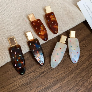 Detail view of a 6-piece vintage acrylic hair clip set with sparkling rhinestones and resin