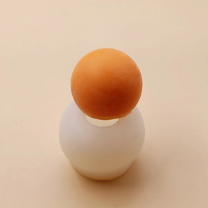 Silicone sphere mold for DIY scented candles showing the flexible texture and orange finished wax ball