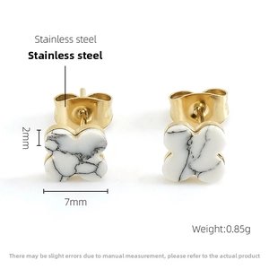 Detail view of 14k gold plated clover stud earrings with marble texture insets