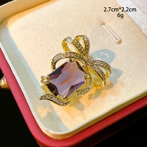 Détails de l'élégante broche nœud en pierre violette avec dimensions 2,7cm x 2,2cm