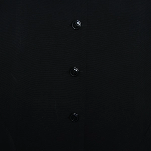 Detailed macro view of three black buttons on a textured V-neck backless dress