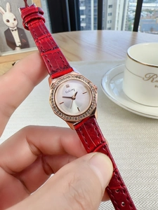 Detail of red crocodile pattern leather strap and rose gold rhinestone octagon watch