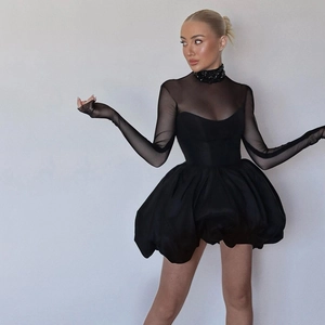 Detail of sheer mesh sleeves and sparkly rhinestone collar on a slim black mini dress