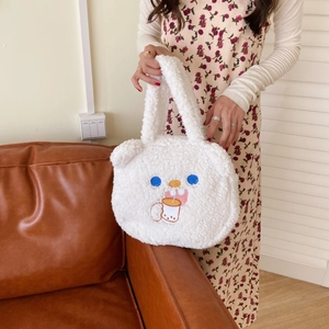 Detail of soft white lamb wool tote bag featuring cute cartoon embroidery and plush texture