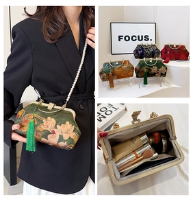 Detail view of vintage floral brocade clutch with pearl chain and tassel charms