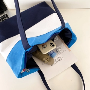 Top view of large canvas tote bag showing interior space with books and umbrella