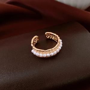Detail of 18K gold-plated ring with small pearls and hammered texture on leather