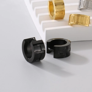 Detailed view of titanium steel huggie earrings featuring cross and Roman numeral engravings