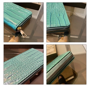 Detail of emerald green crocodile texture wallet with golden zipper and leather finish