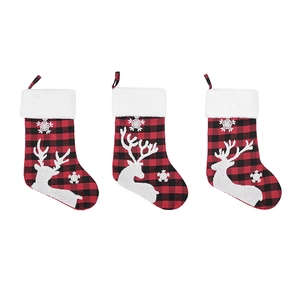 Set of three red and black plaid Christmas stockings with white reindeer embroidery