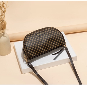 Detail of vintage small brown saddle bag with geometric print and adjustable strap
