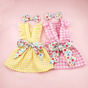 Plaid Christmas dog dresses in pink and yellow with floral bows and matching headbands