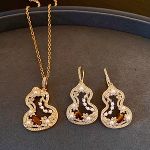 Vue détaillée de la parure de bijoux en forme de gourde avec œil de tigre et perles blanches