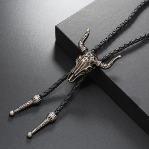 Vintage bull skull bolo tie with black braided leather cord and silver metal pendant