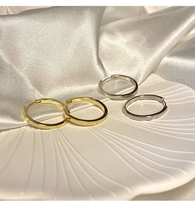 Orecchini a cerchio minimalisti in oro e argento su un vassoio a forma di conchiglia