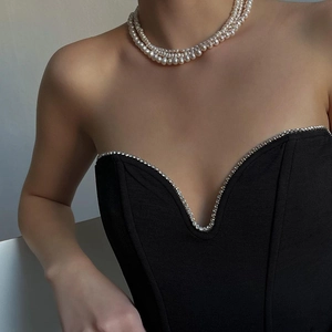 Women's slim black tube top with rhinestones and white pearl necklace detail