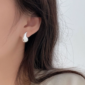 Close-up of teardrop 925 sterling silver stud earring with a polished liquid metal finish