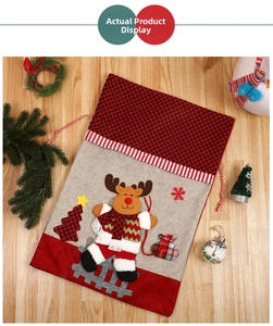 Detail of Christmas gift bag with reindeer applique and festive drawstring closure