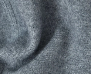 Macro view of grey knit fabric showing high-quality wool fibers and detailed texture