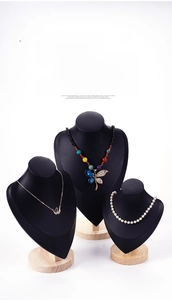 Detail view of swan pendant and dragonfly necklaces on black bust jewelry display