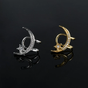 Detailed view of silver and gold moon and star ear cuffs with sparkling crystals