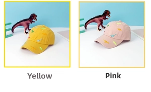 Close-up of yellow and pink children's baseball caps featuring colorful dinosaur embroidery