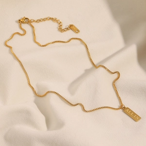 Detail of 18K gold-plated box chain with square pendant engraved with 'ALL IN' text