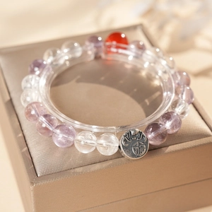Close-up of clear quartz and amethyst beads with a vintage Fu character silver pendant