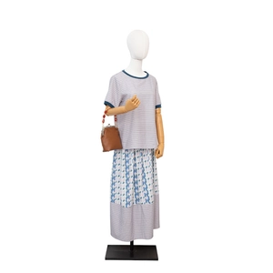 Blau gestreiftes T-Shirt und geometrisch bedruckter langer Rock mit Vintage-Handtasche