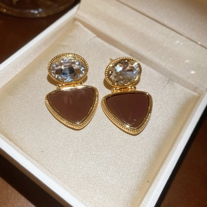 Detail of 18k gold plated triangle earrings with brown enamel and clear crystals