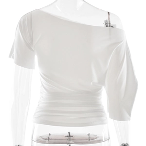 Détail du haut blanc à une épaule, coupe ajustée avec fronces et design asymétrique