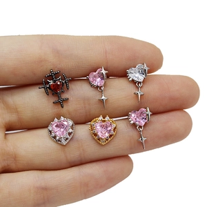 Detailed macro view of heart-shaped ear studs with pink and red zircon stones