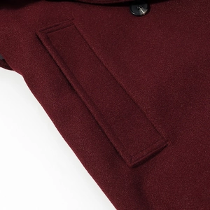 Detailed close-up of wine red wool coat pocket flap and premium matching button