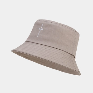 Detailed embroidery of white PEACE text on khaki cotton bucket hat with fine stitching