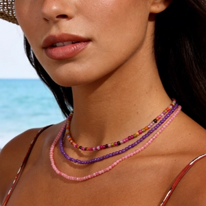 Three-layer beaded necklace with pink quartz and tourmaline on a beach background