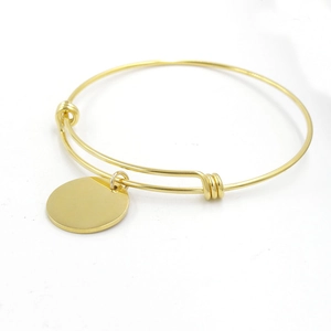 Adjustable gold-tone wire bangle featuring a polished round blank charm for engraving