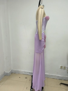 Dettaglio di abito da sera viola con corpetto in pizzo e fiori 3D su tessuto in chiffon