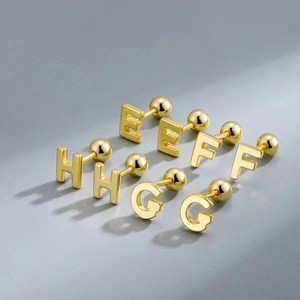 Macro detail of gold-plated stainless steel letter earrings E F G H with screw back