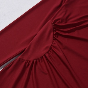 Detail of burgundy ruched dress showing high-quality fabric texture and waist pleat design