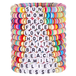 Macro shot of 12 stackable friendship bracelets with colorful clay beads and word charms