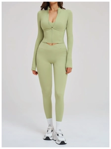 Detail of light green yoga set featuring a zip-up long sleeve top and high-waisted leggings