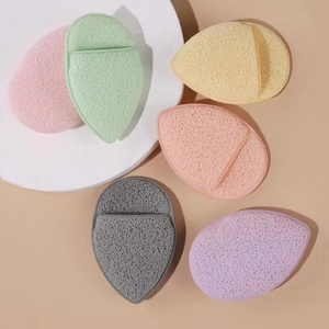 Set of 6 colorful oval facial sponges with porous texture on white circular platform