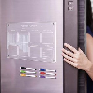 Macro view of clear acrylic weekly planner board on fridge with 6 colored markers
