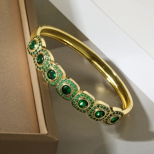 Lussuoso bracciale in rame placcato oro con sei gemme verdi su scatola per gioielli