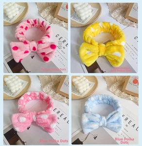 Detailed view of four colorful polka dot coral fleece headbands with large soft bow ties