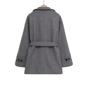 Manteau long en laine gris foncé avec col à revers et ceinture sur fond blanc