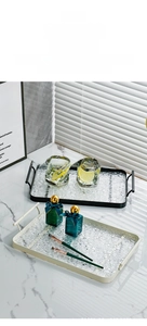 Close-up of rectangular luxury tray with water ripple texture and golden handles