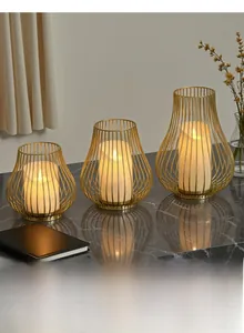 Three-piece gold metal hollow candle holders in various sizes on marble surface