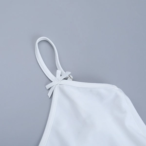 Detail of white slim fit camisole showing thin straps and a delicate bow decoration